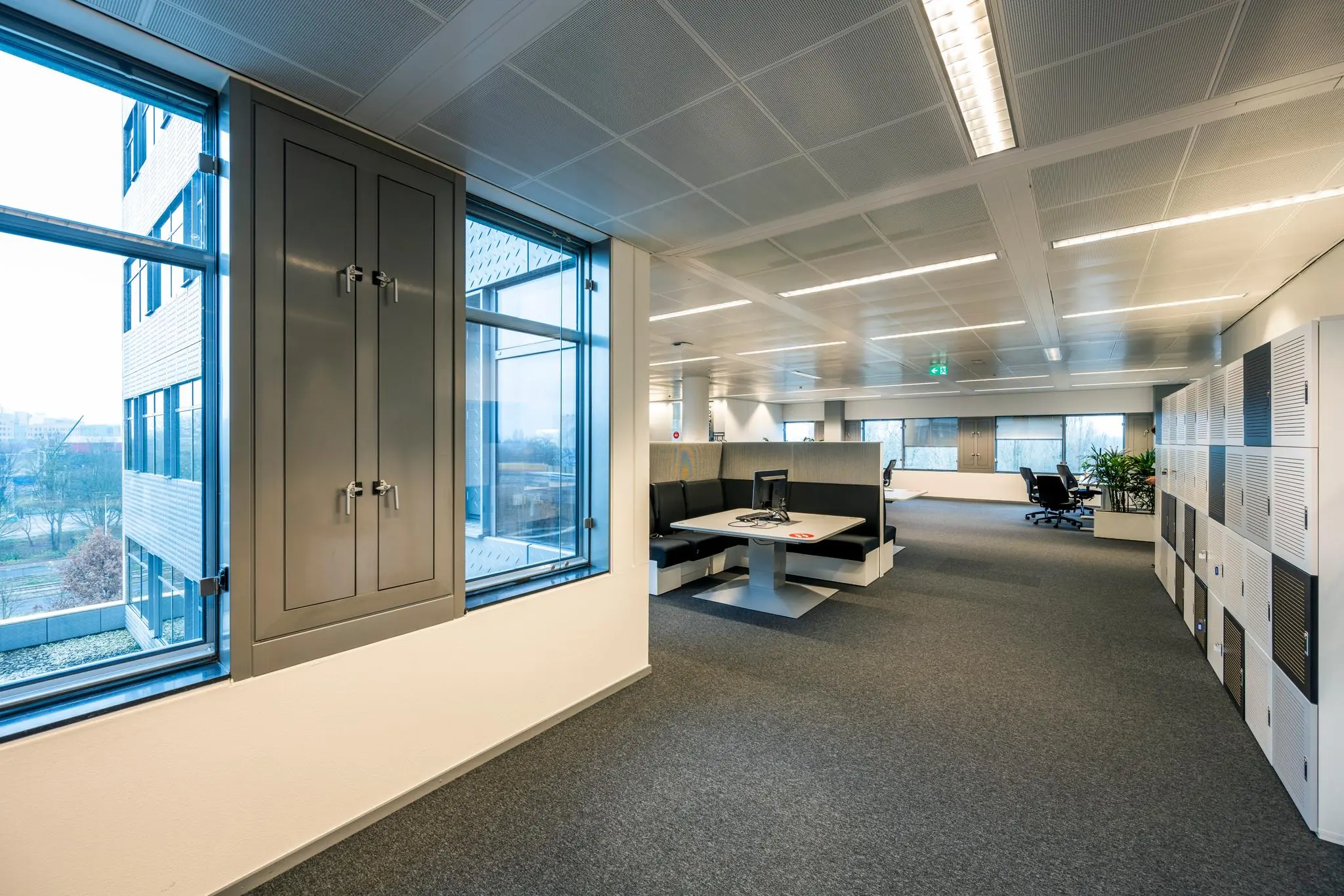 Moderne kantooretage aan de Burgemeester Rijnderslaan met flexibele werkplekken, lockers en grote ramen.